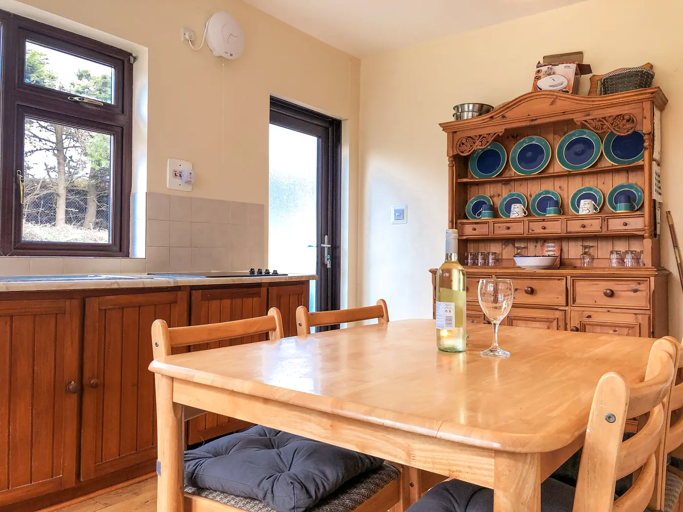 Kitchen with wooden table, dresser and garden windows