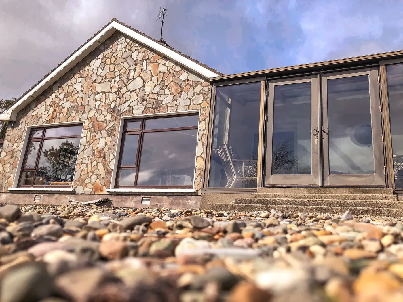 The stone front of the house and the conservatory